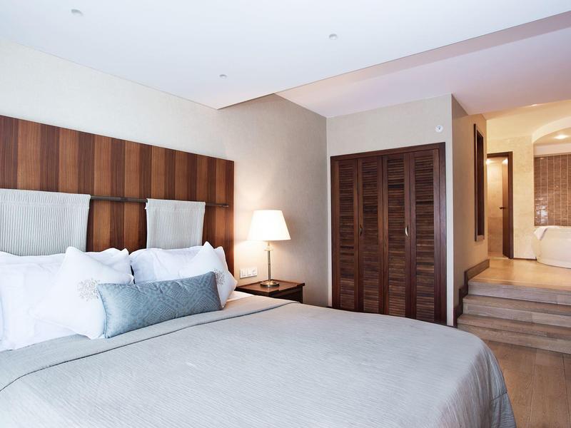 Chambre d'hôtel lumineuse avec lit confortable, table de chevet et accès à la salle de bain attenante.