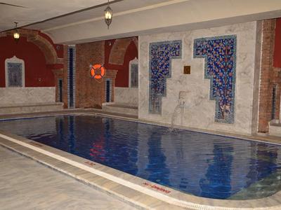 Piscina interior con cascada y azulejos azules decorativos en las paredes de un hotel.