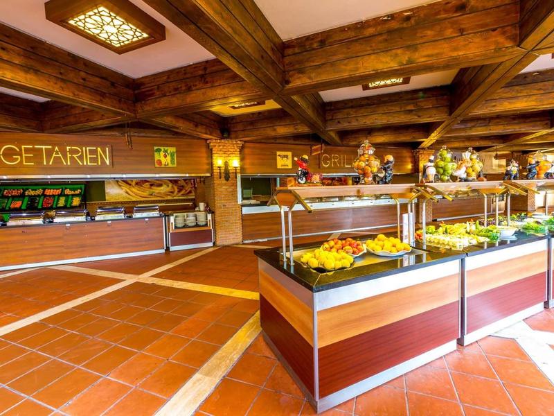 Buffet acogedor con vigas de madera, luz cálida y variedad de alimentos.