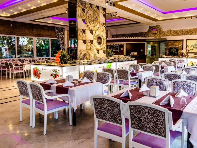 Elegante sala da pranzo con tavoli apparecchiati e accenti viola in un hotel.