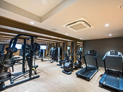 Nowoczesna siłownia z urządzeniami siłowymi i bieżniami w hotelu.