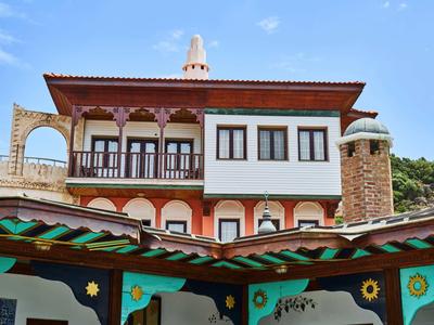 Tradycyjny budynek z rzeźbionymi drewnianymi detalami i kominami pod niebieskim niebem.