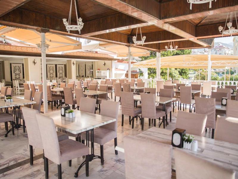 Restaurant lumineux et moderne avec des chaises confortables et des tables dressées sous des poutres en bois.