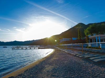 Plage de galets avec quais au coucher du soleil au bord d'une eau calme.