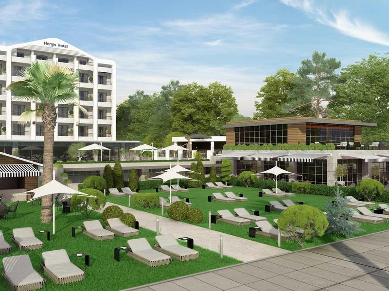 Modernes Hotel mit Liegestühlen, grünen Rasenflächen, Palmen und Gebäuden unter blauem Himmel.