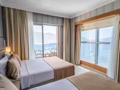 Hotel room with two beds, large windows, and sea view
