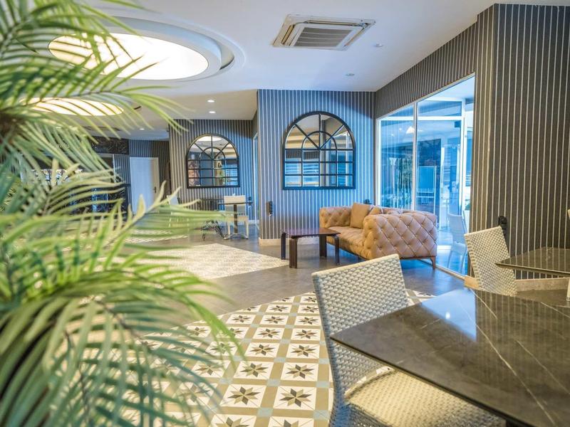 Moderní hotelová hala s posezením a velkou rostlinou.