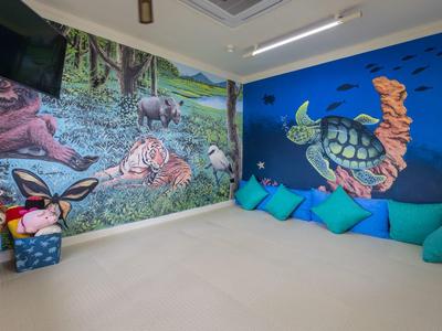 Kids' corner with colorful cushions and wall murals of sea turtles and forest animals.