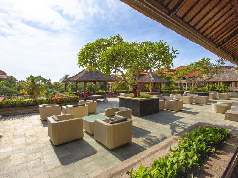 Outdoor hotel area with seating and gazebos under blue sky