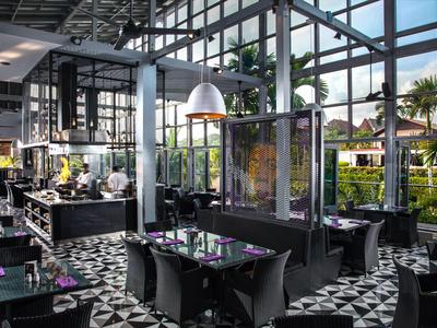 Modernes Restaurant mit großen Fenstern und schwarzem Mobiliar, Tageslicht strömt herein