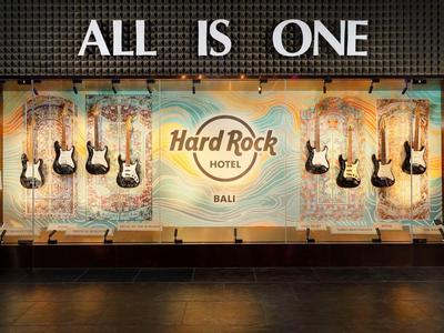 Vetrina illuminata dell'Hard Rock Hotel con chitarre elettriche appese e la scritta 'ALL IS ONE'.