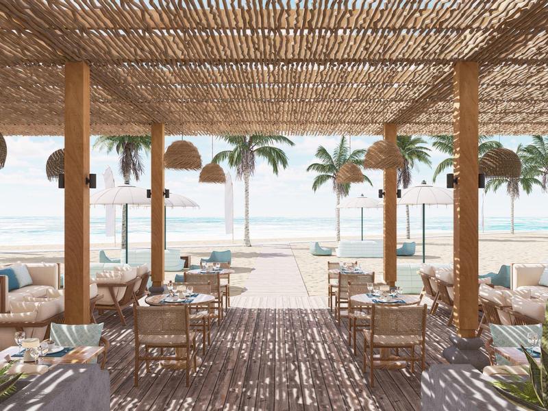 Offenes Strandrestaurant mit Holzdach, Rattanmöbeln und Blick auf Palmen und Meer.