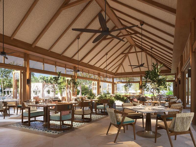 Helles, modernes Restaurant mit Holzdecke, Pflanzen und großen Fenstern mit Blick auf Außenbereiche.