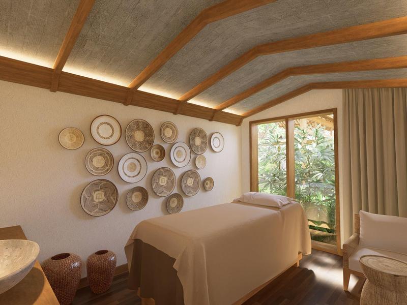 Gemütlicher Raum mit Holzbalkendecke, Massageliege und dekorativen Körben an der Wand.