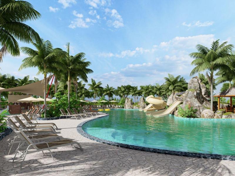 Großer Pool mit Wasserrutschen, Sonnenliegen und Palmen in tropischer Hotelanlage.