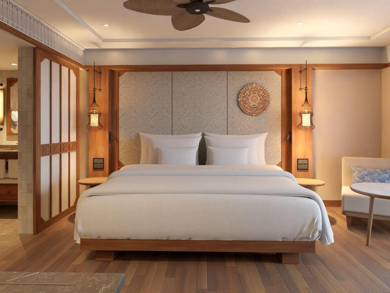 Modernes Schlafzimmer mit großem Bett, Holzböden, Deckenventilator und sitzender Ecke mit Tisch.