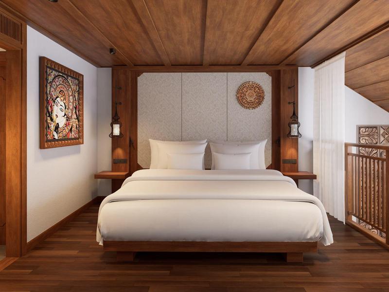 Gemütliches Schlafzimmer mit großem Bett, hölzernem Boden, Wandbild und Holzbalkendecke.