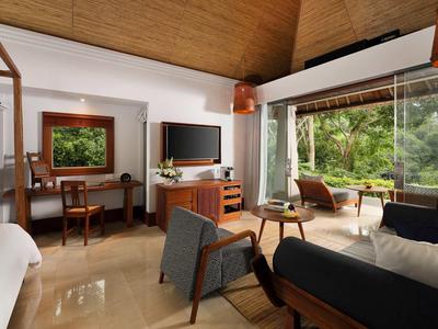 Helles Wohnzimmer mit großen Fenstern, Holzdecke, modernen Möbeln und Blick auf grünen Garten.