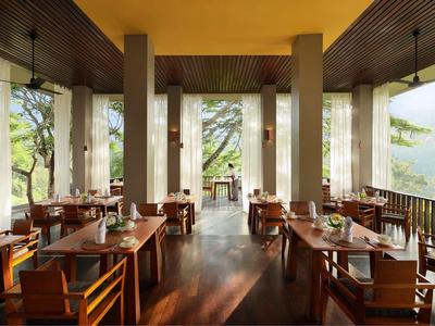 Moderner Speiseraum mit Holzmöbeln, großen Fenstern und natürlichem Licht, ruhige Atmosphäre.