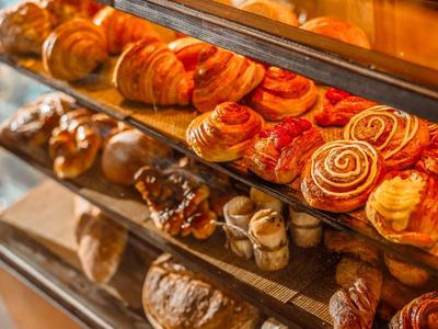 Mostrador con una variedad de panes frescos como cruasanes, bollos y pan en una panadería.
