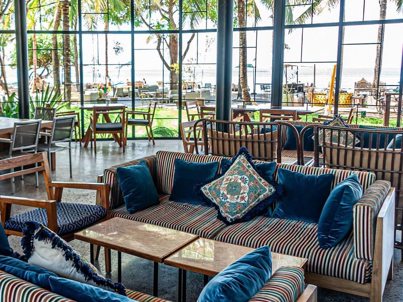 Un jardín con un camino de piedra y estatuas doradas, rodeado de árboles y plantas en un área de templo.