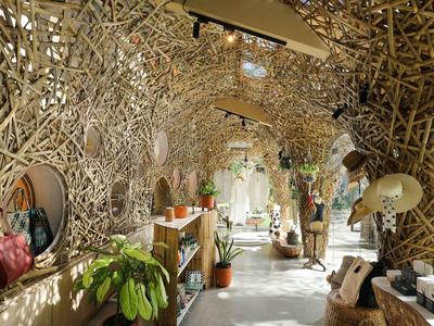 Interieur met verfijnd geweven hout- of bamboestructuren en planten in de ingang.