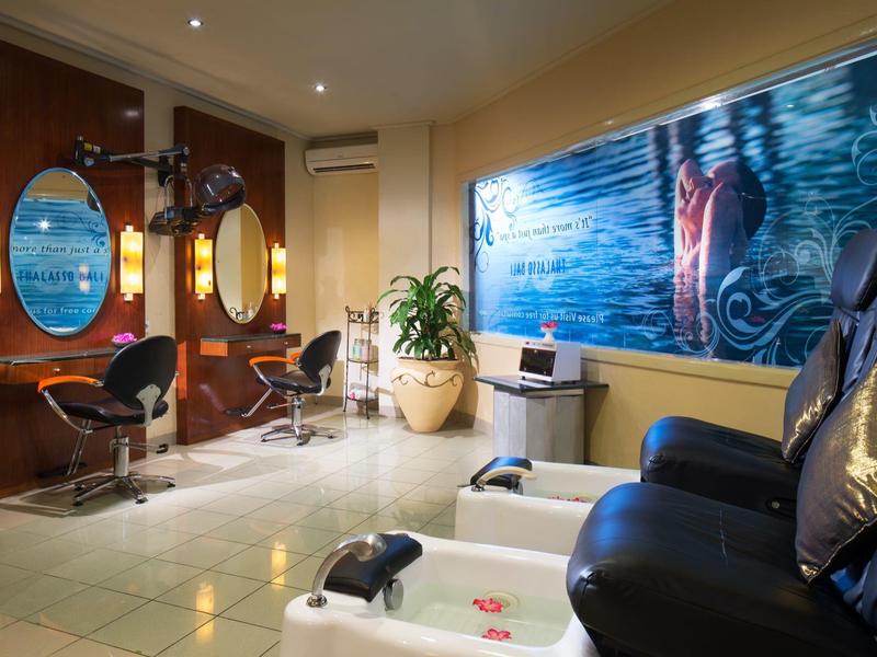 Espace spa moderne avec fauteuils de pédicure et décoration murale stylée dans un hôtel.