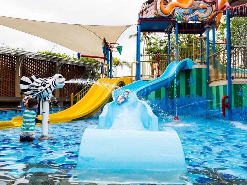 Aire de jeux pour enfants avec toboggan aquatique et structures de jeu colorées dans la piscine