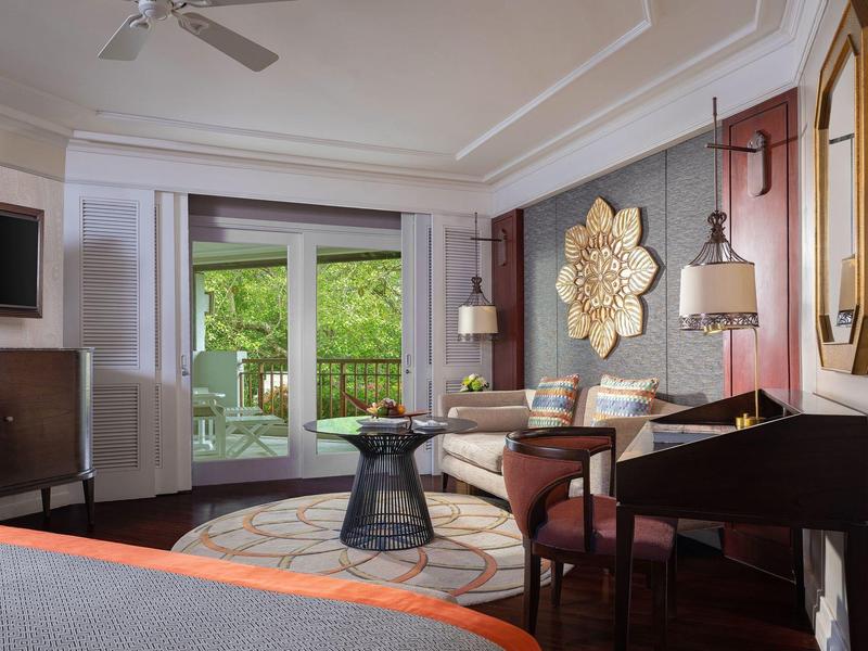 Modern hotel room featuring a seating area, TV, and large window with garden view.