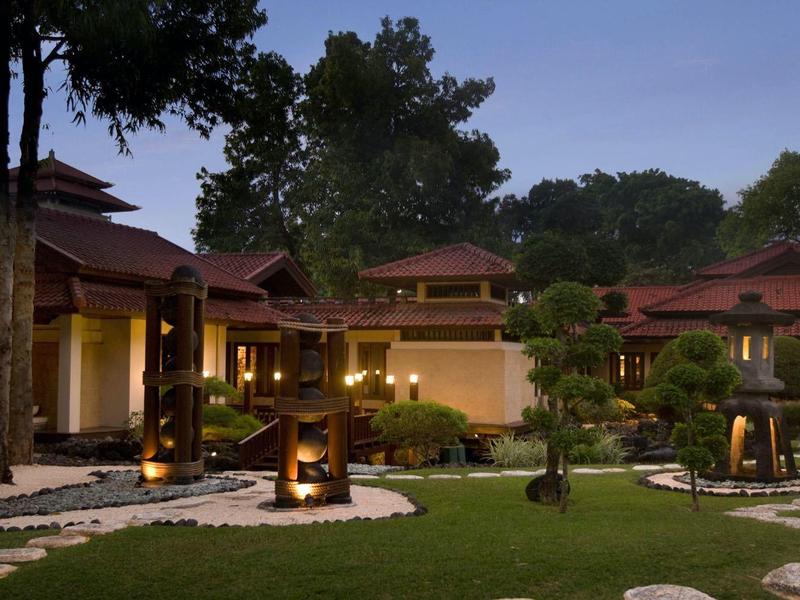Luxurious villas with traditional design and manicured garden at dusk.