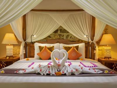 Gemütliches Doppelbett mit Baldachin, dekoriert mit Kissen, Blumen und zwei Tüchern in Herzform.