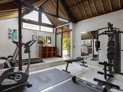 Moderner Fitnessraum mit Trainingsgeräten in einem hellen Raum mit Holzdecke.