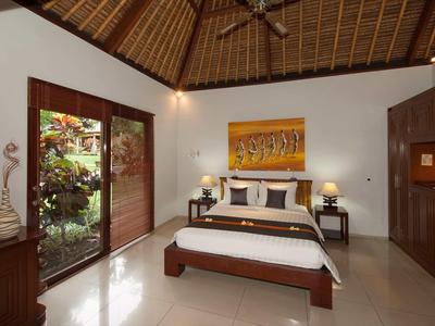 Nowoczesna sypialnia z dużym łóżkiem, drewnianymi meblami i wyjściem do ogrodu.