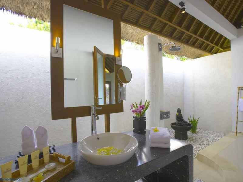 Jasna, nowoczesna łazienka z wolnostojącą umywalką, dużym lustrem i naturalnym światłem.