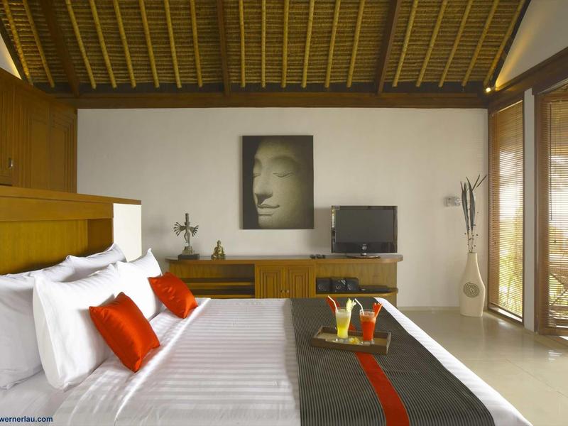 Nowoczesny pokój hotelowy z dużym łóżkiem, białymi i czerwonymi poduszkami, drewnianym sufitem i dużym oknem