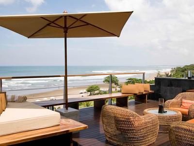 Moderne Dachterrasse mit Sitzgelegenheiten, Sonnenschirm und Meerblick am Strand.