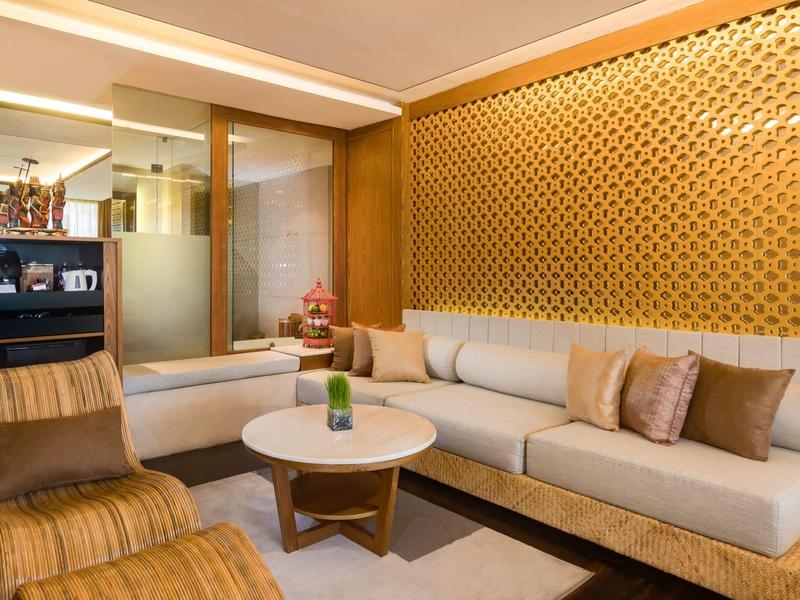 Moderne hotellounge met comfortabele banken en decoratieve wandpanelen.