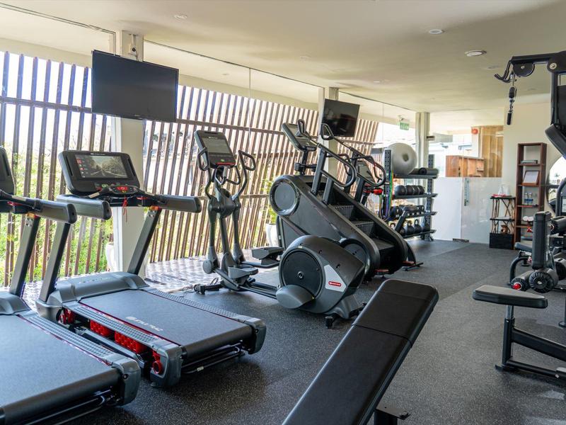 Moderne fitnessapparatuur in een lichte, ruime sportschool met grote ramen.