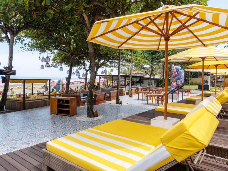 Gele ligstoelen met parasols op het strand met uitzicht op de zee.