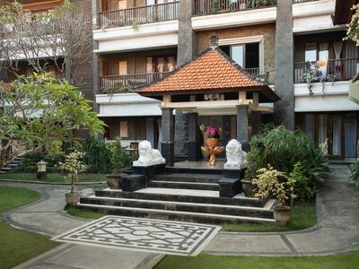 Jardin extérieur avec pavillon en pierre et statues décoratives devant l'hôtel