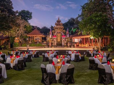Disposition de tables et chaises en extérieur sur une pelouse près de temples au crépuscule.
