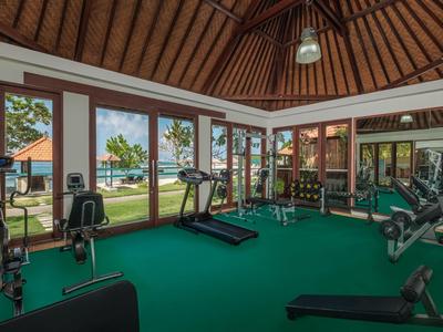 Gimnasio con equipo moderno y vista a la piscina exterior y jardín