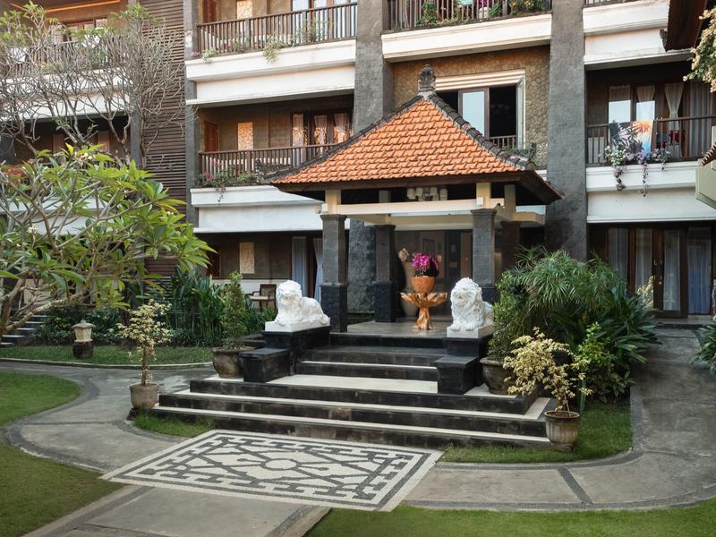 Jardin extérieur avec pavillon en pierre et statues décoratives devant l'hôtel