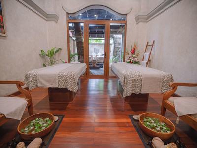 Wnętrze z dwoma stołami do masażu, drewniana podłoga i relaksująca atmosfera