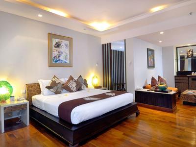 Nowoczesny pokój hotelowy z łóżkiem podwójnym, drewnianą podłogą i przytulnym oświetleniem.