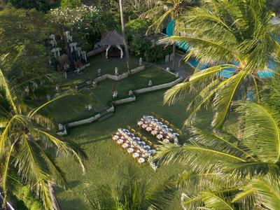 Zielony ogród z białymi rzędami krzeseł między wysokimi palmami na wydarzenie na świeżym powietrzu