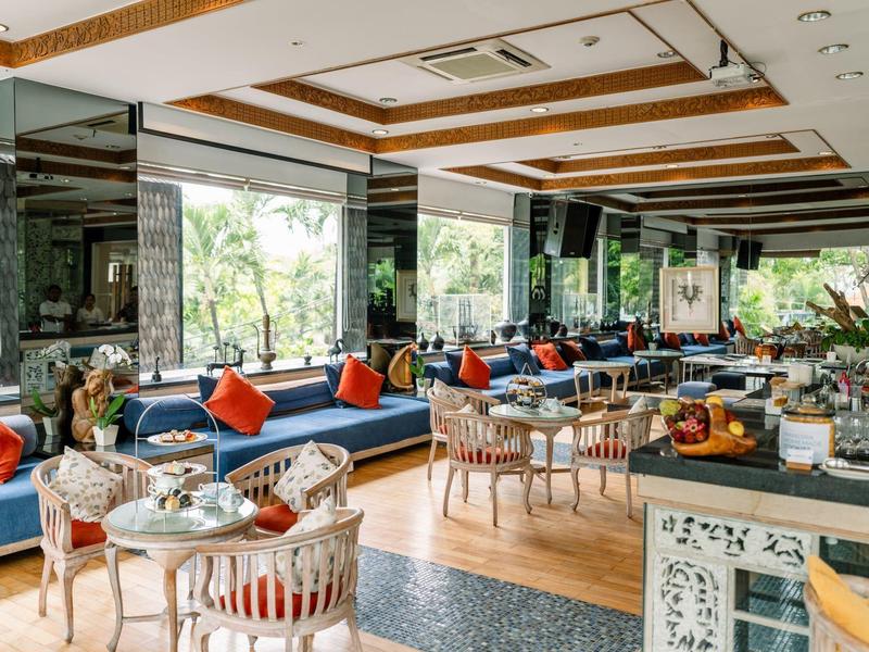 Jasno urządzone lobby hotelowe z wygodnymi miejscami do siedzenia i dużymi oknami.