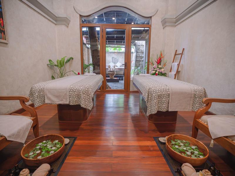 Wnętrze z dwoma stołami do masażu, drewniana podłoga i relaksująca atmosfera