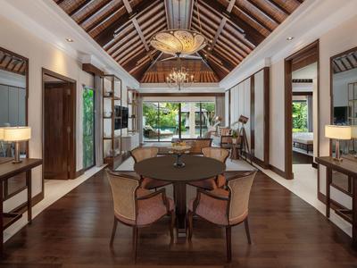 Elegantní hotelový interiér s dřevěnými podlahami, kulatým stolem a výhledem na zahradu.