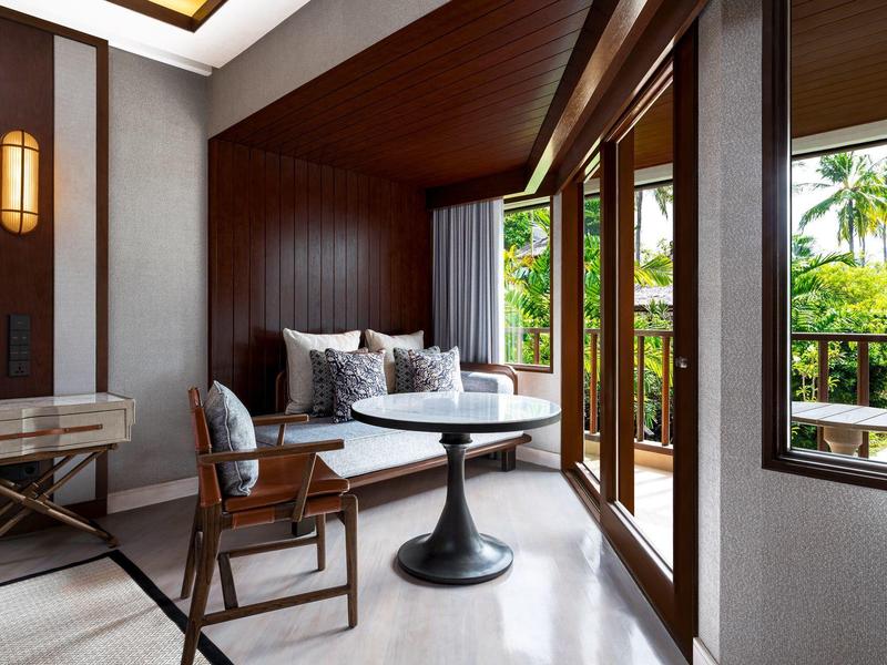 Moderní hotelový pokoj s velkou postelí, balkonem a tropickým výhledem.